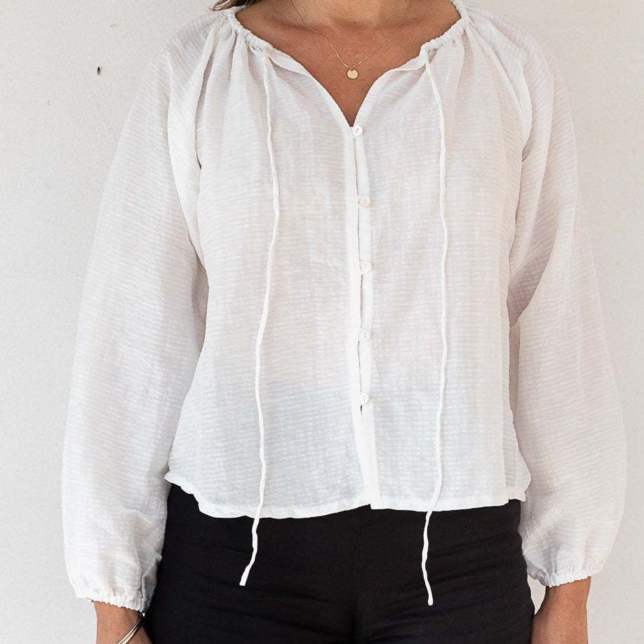 White silk/cotton/linen blouse with delicate detail, elastic cuffs and neck tie